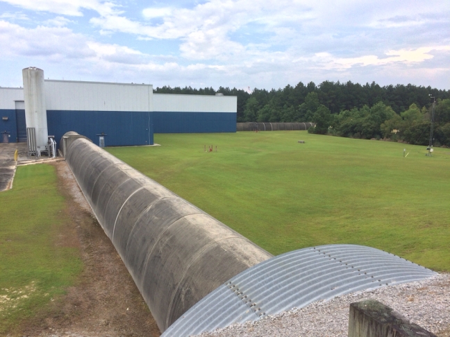 The two LIGO tunnels – the second is visible in front of the tree line – converge on the main building, where a laser beam is split and sent shooting down both sides.